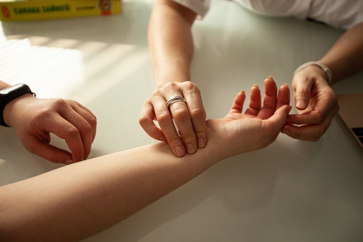 Woman getting pulsed checked by a practitioner