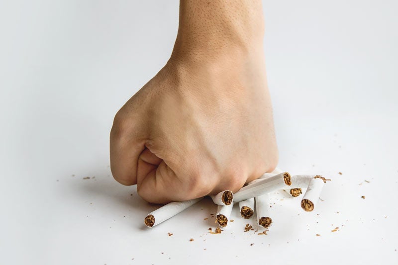 Fist crushing cigarettes