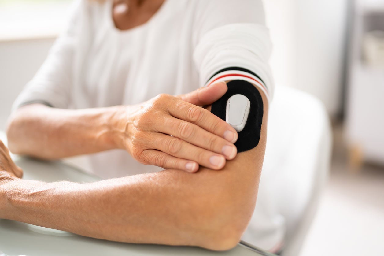 Woman measuring blood glucose levels in arm