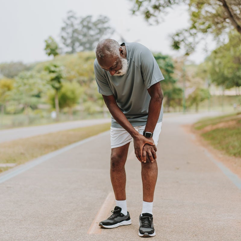Older man holding knee